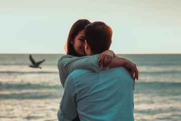 happy wedding couple on the beach watching the ocean