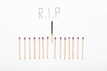 Whole matches, burnt one and word RIP on white background