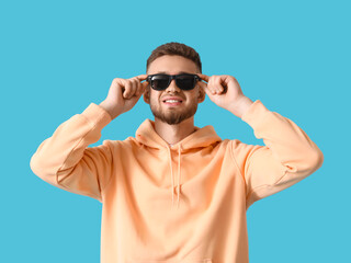 Fototapeta premium Young guy in stylish hoodie on color background
