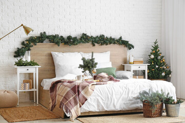 Interior of stylish bedroom with fir branches decorated for Christmas