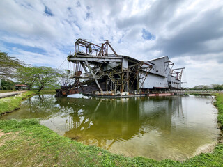 Old tin mining dredge in Tanjung Tualang, Perak, Malaysia, restored into exhibition building for visitors to learn about tin mining history and process in country.