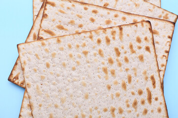 Jewish flatbread matza for Passover on blue background, closeup