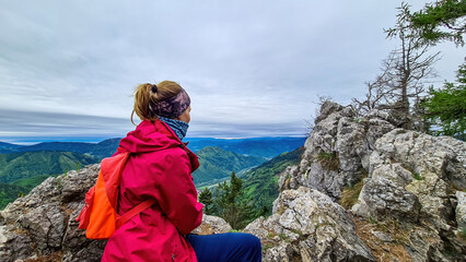 Woman admiring the scenic view from the summit of mount Roethelstein near Mixnitz in Styria,...
