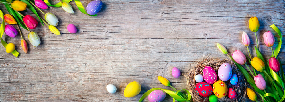 Easter Eggs - Painted Decoration In Nest With Tulips On Natural Wooden Plank