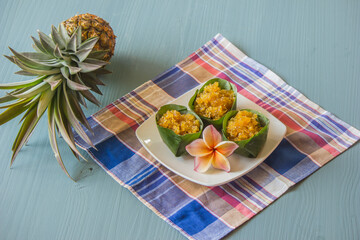 Stir-fried pineapple with banana leaves placed in a saucer, cloth and pineapple