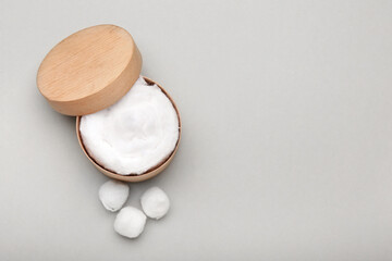 Wooden box with soft cotton wool on light background