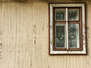 The wall of an old wooden house with a window