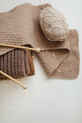 Fototapeta na wymiar Knitting needles with threads, beige yarn. Hobby for women concept. Knitting accessories