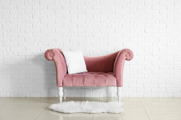 Stylish sofa near white brick wall