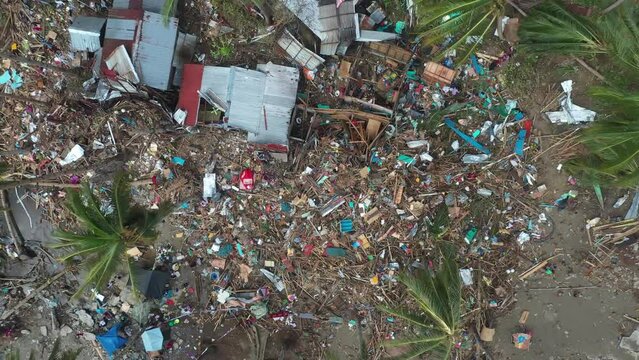 Damages And Trashes Left After The Strong Typhoon Odette In Coastal Village Of Southern Leyte In The Philippines. Aerial Drone Ascending