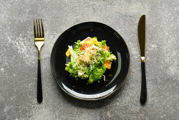 Plate of tasty vegan Caesar salad on grey background