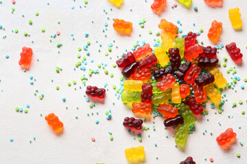 Sweet jelly bears and sprinkles on light background