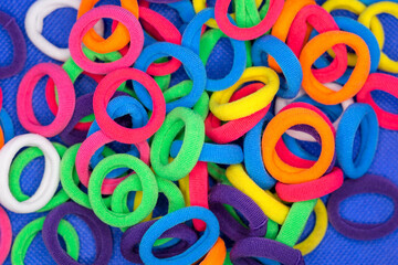 A bunch of colorful bright rubber bands for little girls blue background.