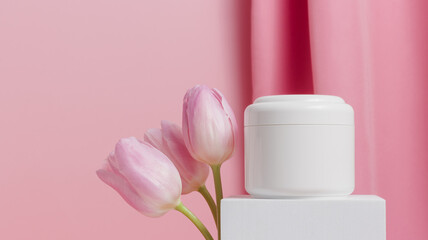Fototapeta na wymiar Banner with white mockup cosmetic bottle of face cream on podium with tulips flowers, spring concept, copy space