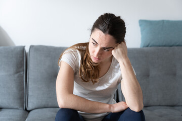 Obraz premium Depressed woman sitting on couch. Depression, anxiety and mental health concept.