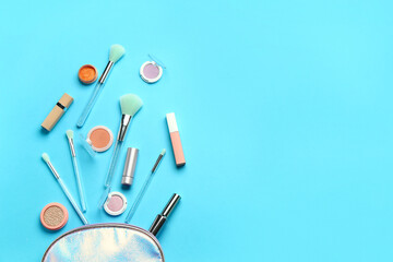 Composition with makeup brushes and cosmetic products on blue background