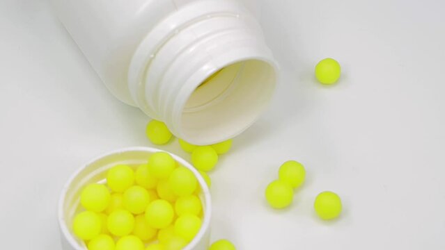 yellow pills or vitamins on a white background