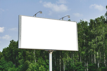 Blank billboard mockup with white screen. Against the backdrop of nature and blue sky. Business...