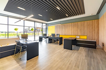 Modern office space with tables and chairs, computers and office supplies with no employees