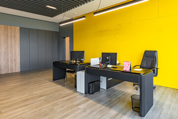 Modern office space with tables and chairs, computers and office supplies with no employees
