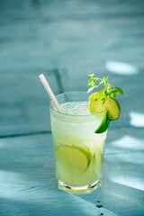 Caipirinha drink with lime on a blue wooden table. Typical Brazilian drink made with cachaça, lemon, ice and sugar.