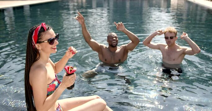 Happy multiracial friends having fun on a pool party on vacation