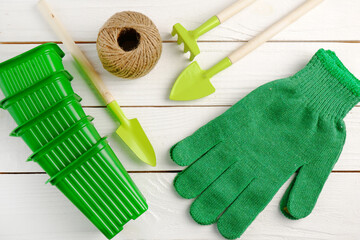 Garden supplies:shovels, rakes; green gardening gloves, green pots for seedlings, burning in a ball...