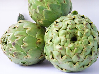 Obraz premium Close-up of a group of fresh flowers of artichokes isolated over a white background 
