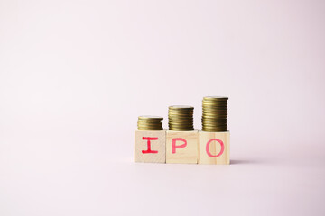 IPO text ,Initial Public Offering on wooden block with stack of coins