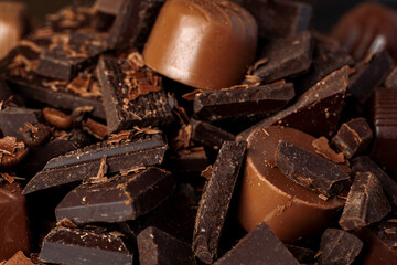 Chocolate candies and chocolate pieces pile for background
