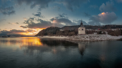 Fototapeta na wymiar sunset on the coast of the Liptovska Mara dam with the tower of the old church