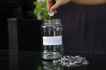 businessman holding coins putting in glass. concept saving money for finance accounting. Indonesian rupiah notes in one hundred thousand denominations and rupiah coins