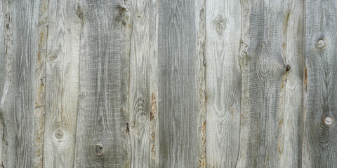 Panoramic banner of wooden wall texture close up.
Natural wood background.
Old wooden wall of a house made of vertical planks in the countryside.