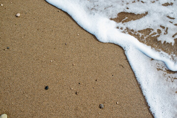 Obraz premium Soft wave of blue ocean on sandy beach. Background.