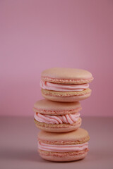close up of pink macaroons with pink buttercream on pink background 