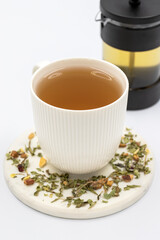 Relax herbal tea on a white background. Herbal tea prepared with lemon balm leaves, jasmine flower, apple peel, orange, lemon and hibiscus particles.
