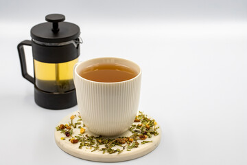 Relax herbal tea on a white background. Herbal tea prepared with lemon balm leaves, jasmine flower, apple peel, orange, lemon and hibiscus particles.