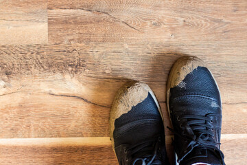 Dirty men's shoes black on the floor, top view. Dirty sloppy shoes in the apartment on the floor. High quality photo