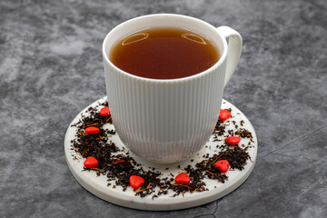 Love herbal tea. Close-up herbal tea. Herbal tea prepared with black tea, fruit flavored dragee sugar, safflower flower, strawberry flavor particles.