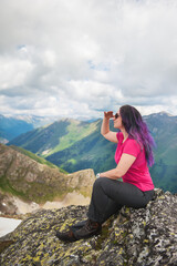 Naklejka na ściany i meble Beautiful Woman hiker sitting on the top of mountain