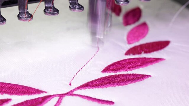Embroidery design. Machine embroidery on a white towel with pink thread. 4k video Close up.
