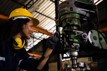 Engineering standing and hold screw nut machine in the CNC factory. Background of older factory with machine and engineer working and maintenance.