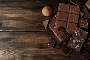 Broken chocolate bars on dark wooden background
