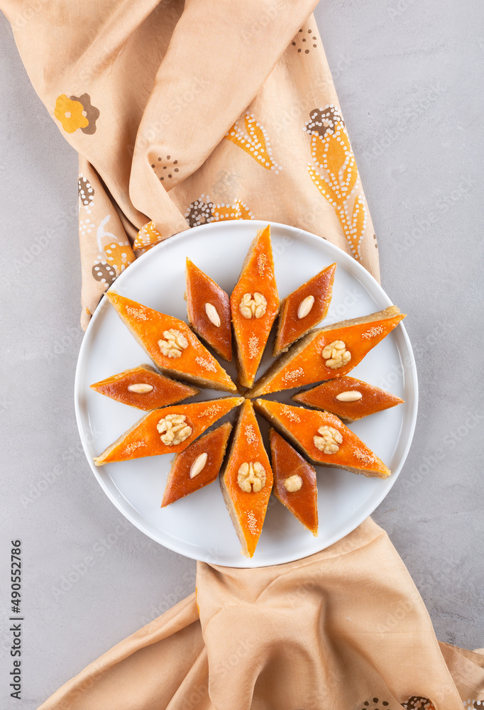 Wall mural Plate of Azerbaijani national pastries for Novruz - Ganja and Baku style pakhlava on silk scarf kelagai for Novruz, spring equinox and new year celebration in March. Copy space  