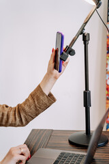 Woman Using Smartphone on Phone Holder Photography. Girl Use Cellphone for Search Information and Working on Laptop. Businesswoman Work at Workspace and Checking Message on Digital Electronic Device