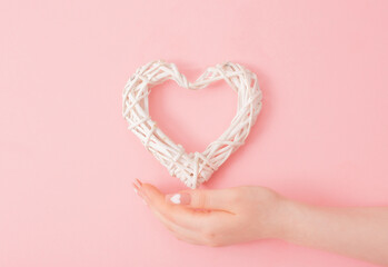 female hands with beautiful long nails with  manicure with  heart pattern and wicker heart