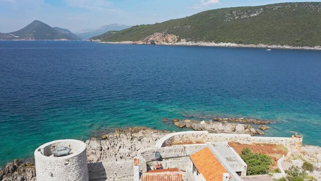 Castle on the island of Otocic Gospa in the Bay of Kotor. Montenegro. Top view of the island with a fortress. Drone. Pleasure boats in the bay. 
