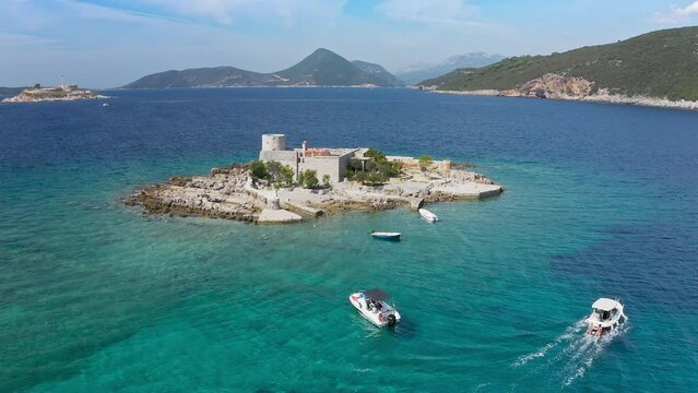 Castle on the island of Otocic Gospa in the Bay of Kotor. Montenegro. Top view of the island with a fortress. Drone. Pleasure boats in the bay. 
