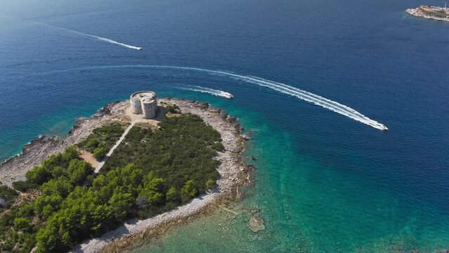 Castle on the island of Otocic Gospa in the Bay of Kotor. Montenegro. Top view of the island with a fortress. Drone. Pleasure boats in the bay. 
