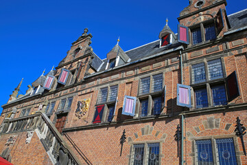Fototapeta na wymiar Low angle view on medieval renaissance red brick style facade against cloudless blue sky